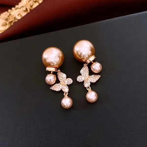 Vue détaillée des boucles d'oreilles papillon plaquées or 18 carats avec perles et cristaux