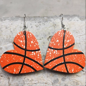Detail view of heart-shaped basketball faux leather earrings with silver fish hooks