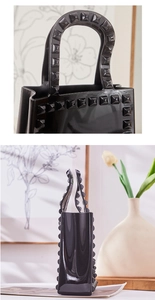 Detailed macro view of black PVC jelly bag featuring iconic gold pyramid studs and glossy finish