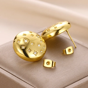 Macro detail of gold star studs with cubic zirconia on a luxury velvet jewelry box