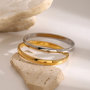 Polished stainless steel bangle bracelets in gold and silver finish on stones