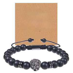 Macro shot of black matte beaded bracelet with lion head charm and gift card for boyfriend
