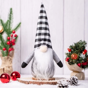 Christmas gnome ornament with black and white plaid hat on rustic wooden base