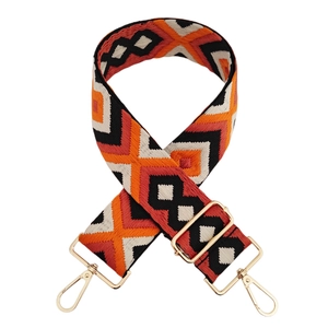 Close-up of geometric diamond jacquard bag strap with adjustable gold hardware