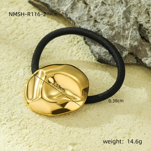 Elegant gold pleated metal hair tie with black elastic band on natural stone base