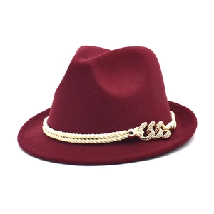 Detail of burgundy wool fedora hat with beige braided rope and gold hollow chain trim