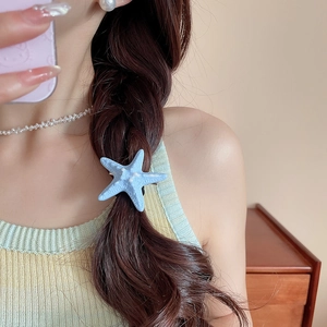 Close-up of a blue starfish hair clip with textured matte finish on a female model