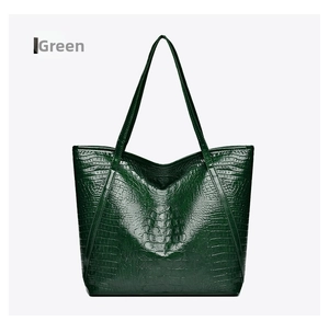 Detailed view of large green crocodile pattern tote bag with slim shoulder straps