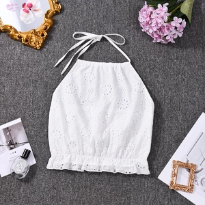 Flat lay of a white lace crop top with ruffle hem and embroidered eyelet textures