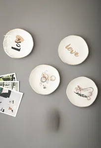 Detailed view of irregular 4-inch ceramic jewelry trays with gold rim and elegant prints