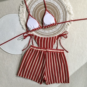 Detailed flat lay of red and white striped crochet three-piece bikini set with shorts