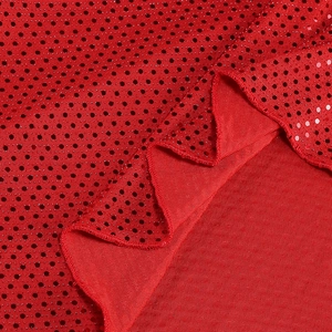 Détail du tissu à paillettes rouges avec texture à pois et ourlet à volants