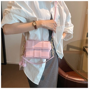 Sac bandoulière tressé rose avec chaîne dorée et pompon en cuir pour femme élégante