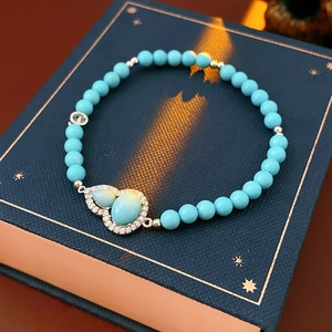 Close-up of turquoise beaded bracelet featuring double gourd pendants and sparkling zircons