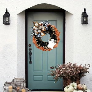 Close-up of Halloween ghost wreath with burlap bow hanging on a light blue front door