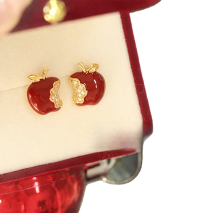 Red enamel apple stud earrings with gold plating and zircons in a red velvet jewelry box