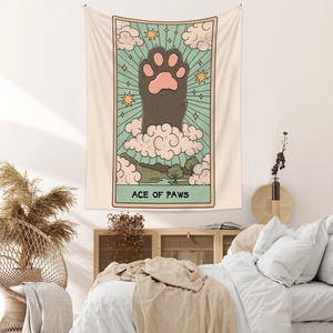Detail of tarot style Ace of Paws cat tapestry hanging over a cozy bedroom headboard