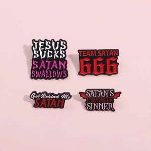 Lot de quatre badges en émail noir à thème satanique sur un fond rose épuré