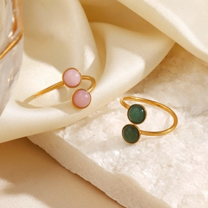 Minimalist stainless steel open rings with pink and green stones on white silk base