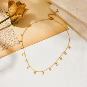 Elegant gold stainless steel necklace with star and moon charms on a stone background