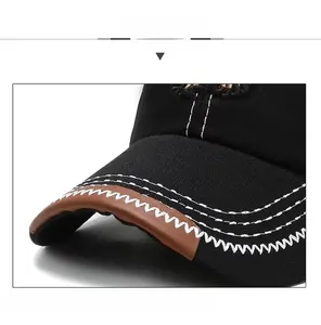 Close-up of black baseball cap brim featuring white contrast stitching and brown leather piping