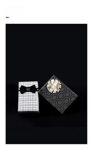 Detail of luxury gift boxes with black grid and gold hexagon patterns and ribbon bows