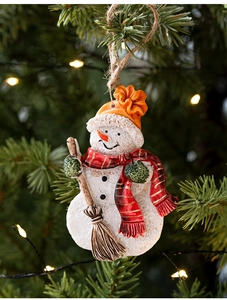 Detailed close-up of resin snowman ornament with knitted hat on a Christmas tree branch