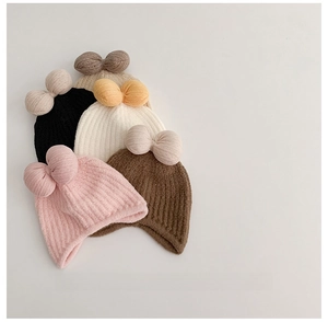 Close-up of knit baby beanies in various colors featuring large decorative soft bows