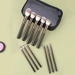 Flat lay of 11-piece makeup brush set with wooden handles and black zipper pouch