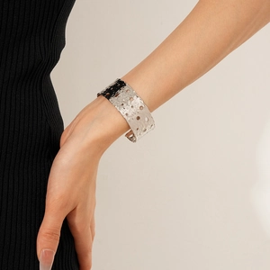 Detailed view of silver hammered metal cuff bracelet with circular hollow design