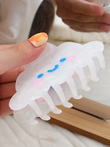 Detail of white cloud-shaped hair claw clip with colorful smiling face pattern