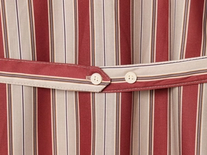 Gros plan sur tissu rayé rouge et beige avec ceinture assortie et boutons crème