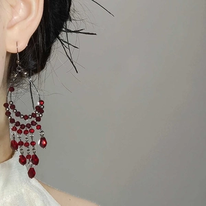 Detail view of retro red glass bead tassel earrings on model showing 6cm drop length