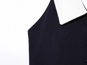 Dettaglio del top blu scuro con colletto a revers bianco e trama del tessuto liscio