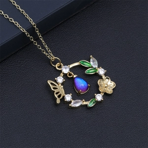 Gros plan détaillé du pendentif papillon fleuri avec cristal violet et pierres zircons