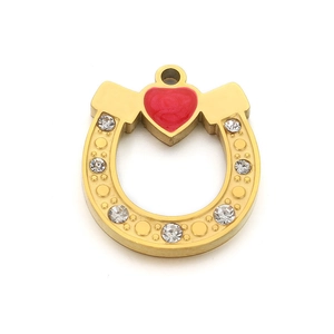 Golden horseshoe pendant with red enamel heart and sparkling crystals on white background