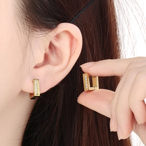 Macro detail of 18k gold plated square hoop earrings with sparkling zircon inlay