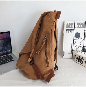 Close-up of durable brown canvas sling bag with metal zipper and premium texture