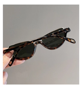 Close-up of tortoise shell cat eye sunglasses with gold T-shaped metal detailing