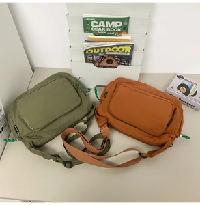 Close-up of olive green and caramel nylon messenger bags with adjustable wide straps