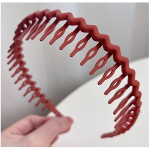 Close-up of matte brick red wavy headband with inner anti-slip teeth detail