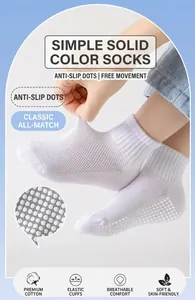 Detail of white cotton children's socks featuring anti-slip grip sole and high elastic cuff