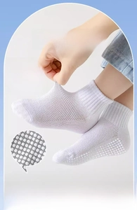 Detail of white cotton children's socks featuring anti-slip grip sole and high elastic cuff