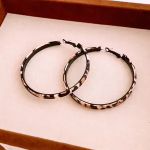 Vintage leopard print round hoop earrings with black inner band on luxury tray