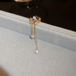 Detail of golden tassel ear cuff with zircon flowers and drop imitation pearls