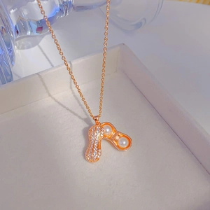 Collier pendentif cacahuète en or rose élégant avec perles et zircon dans un écrin