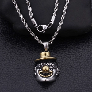 Macro shot of dual-tone silver and gold clown pendant on a twisted chain over leather
