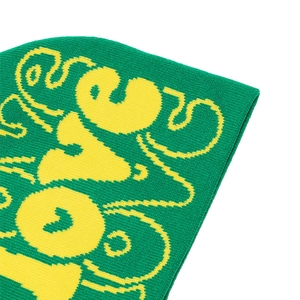 Detailed knit texture of green and yellow acrylic beanie with jacquard patterns