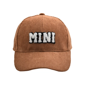 Close-up of brown corduroy baseball cap texture and white MINI embroidery letters