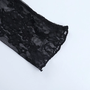 Close-up of black lace fabric showing intricate floral hollow-out patterns and fine mesh